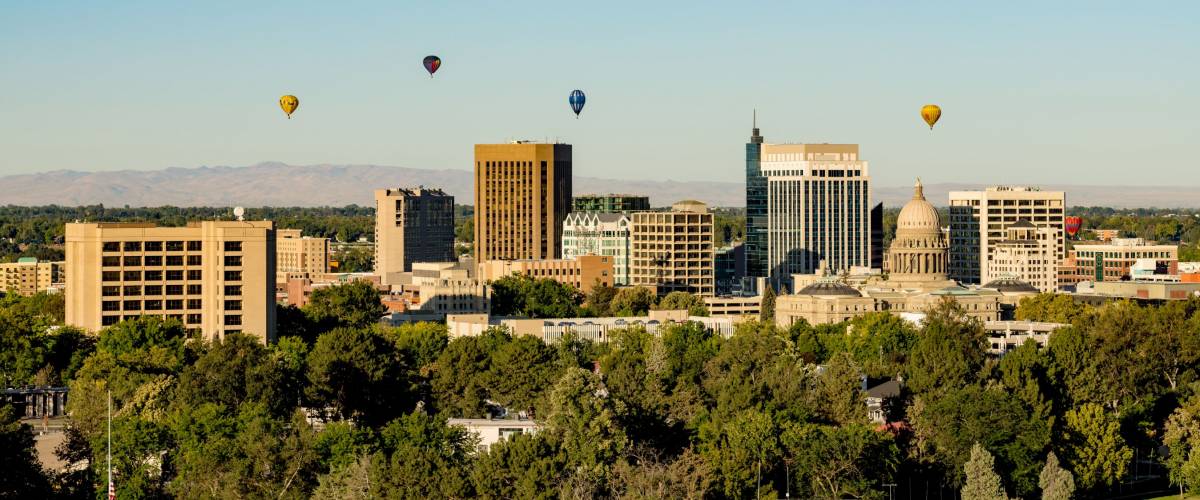 Colorful ballons in a blue sky over the little city of Boise Idaho