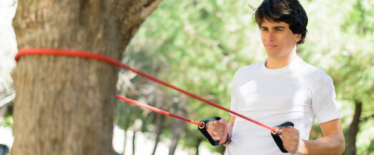 Young Man Exercising With Stretch Band