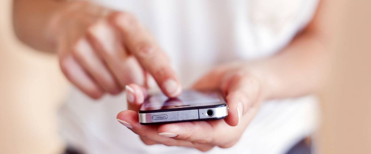 Young woman using apps on a mobile touchscreen smartphone.