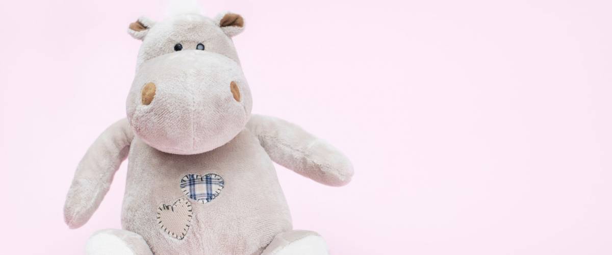 Hippo toy on a pink background, copy space