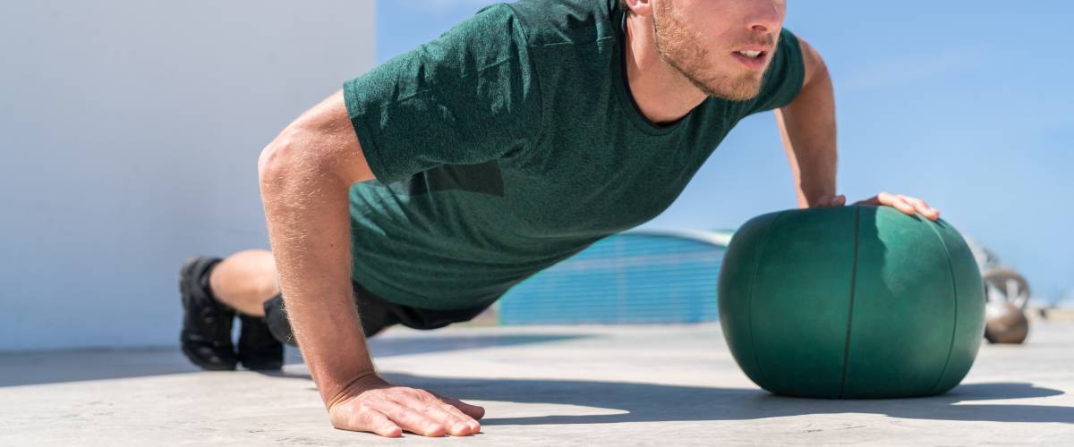 Man doing pushups using a ball