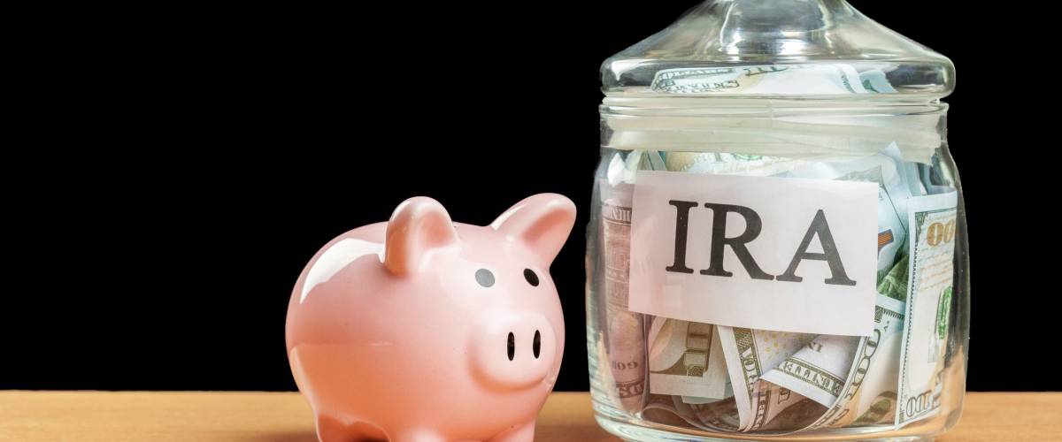 glass jar used for saving US dollar bills and notes for IRA retirement fund
