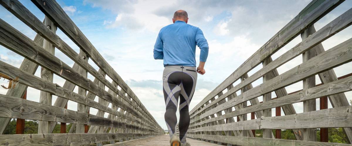 senior man is running on a long trestle over Long Pine Creek - recreational Cowboy Trail in northern Nebraska