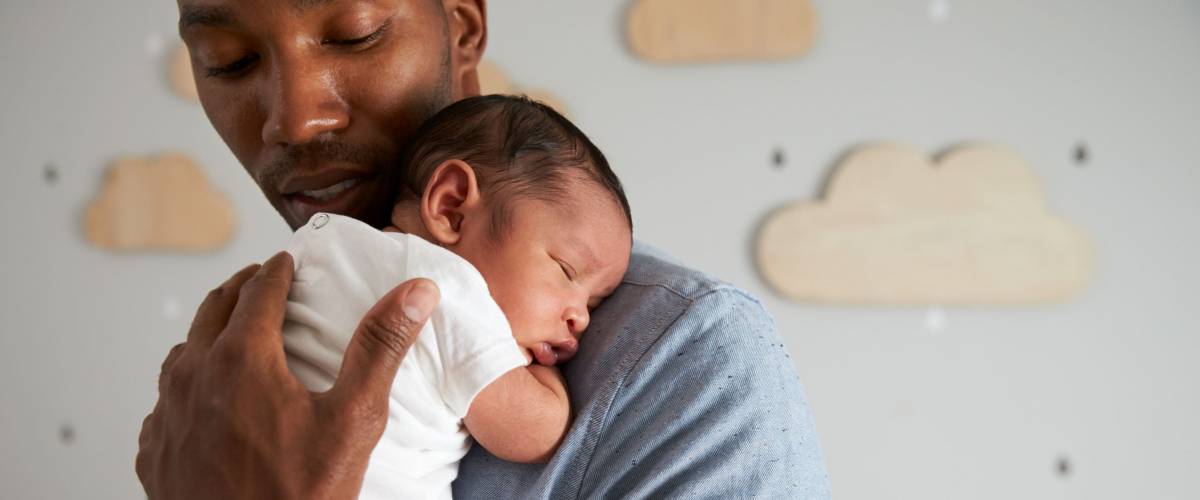 Father Holding Newborn Baby Son In Nursery