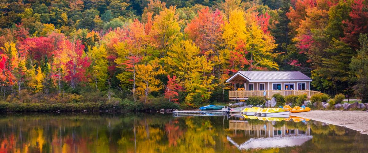 Boathouse and fall colors reflecting in Echo Lake, in Franconia Notch State Park, New Hampshire.