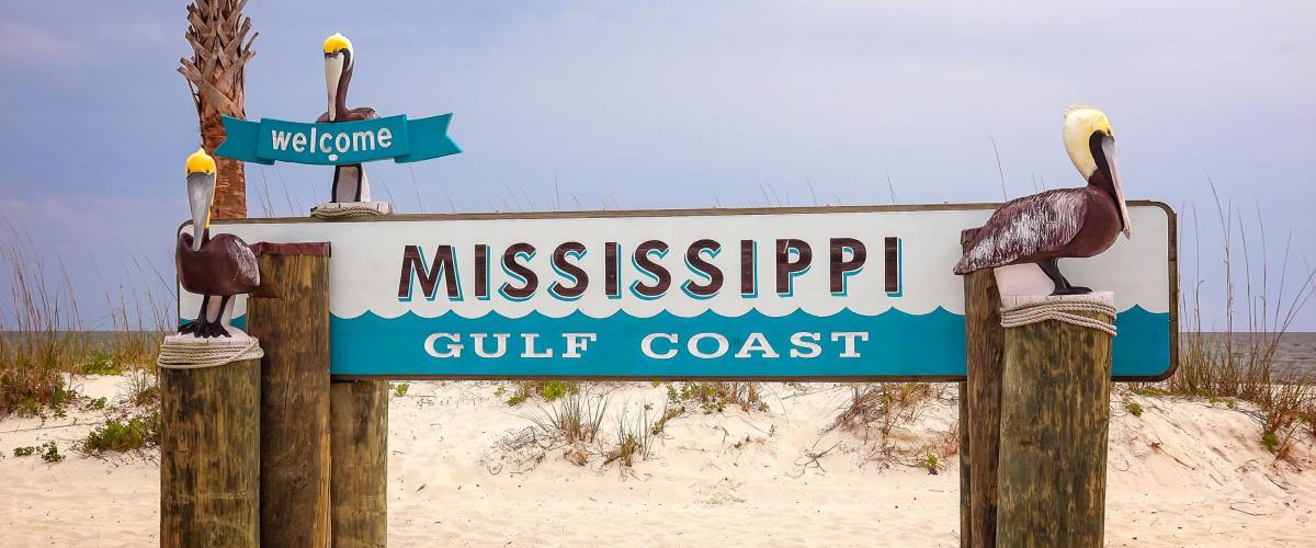 Welcome to Mississippi Gulf Coast sign on sandy beach in Gulfport