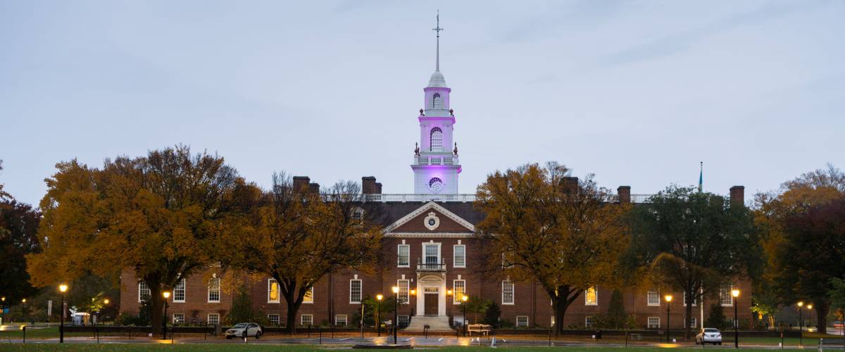 Pink light lights the capital dome tower on top of the Delaware state capital building at night
