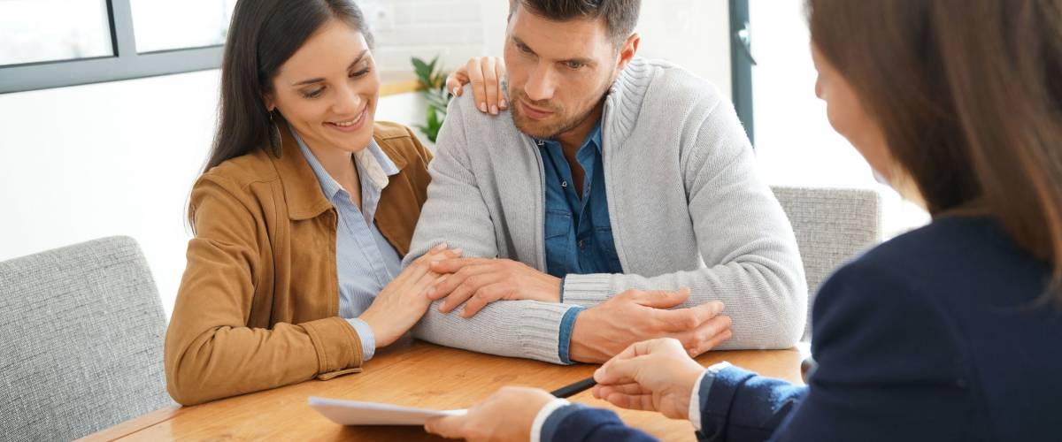 Couple meeting financial adviser for home investment contract