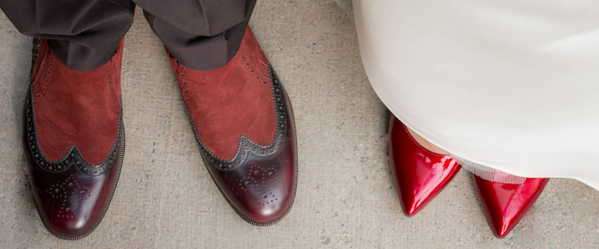 Top view of grooms and brides legs in stylish shoes on the background. shoes of the bride and groom top view