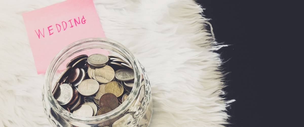 many coins in a money jar with wedding label on jar. wedding concept. saving concept
