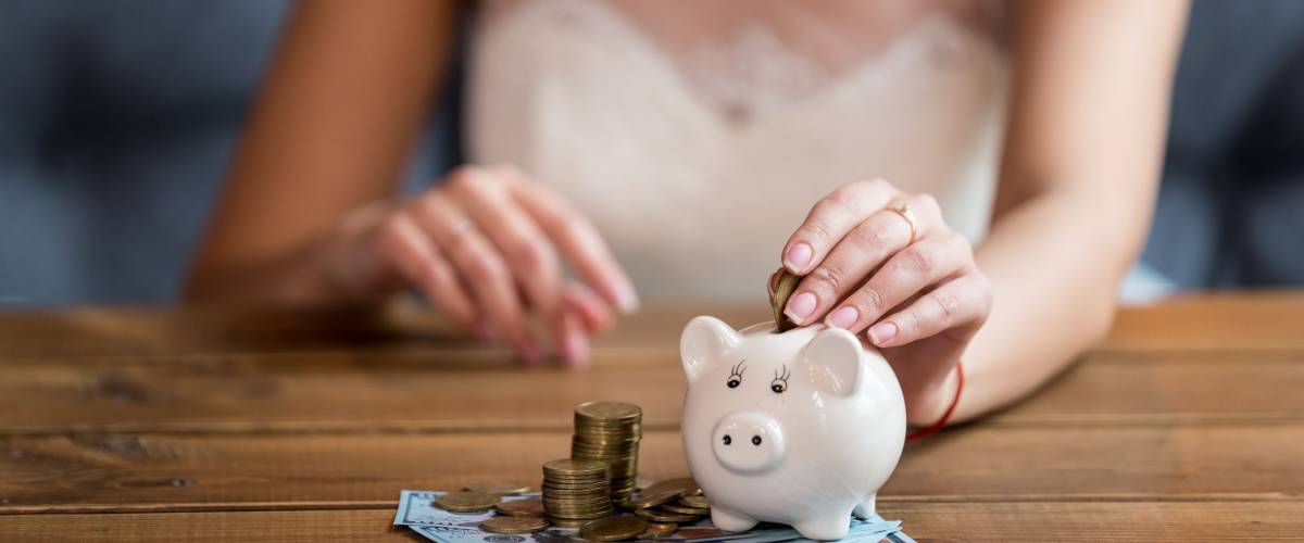 The bride counts the money. Wedding expenses. Bride with a piggy bank