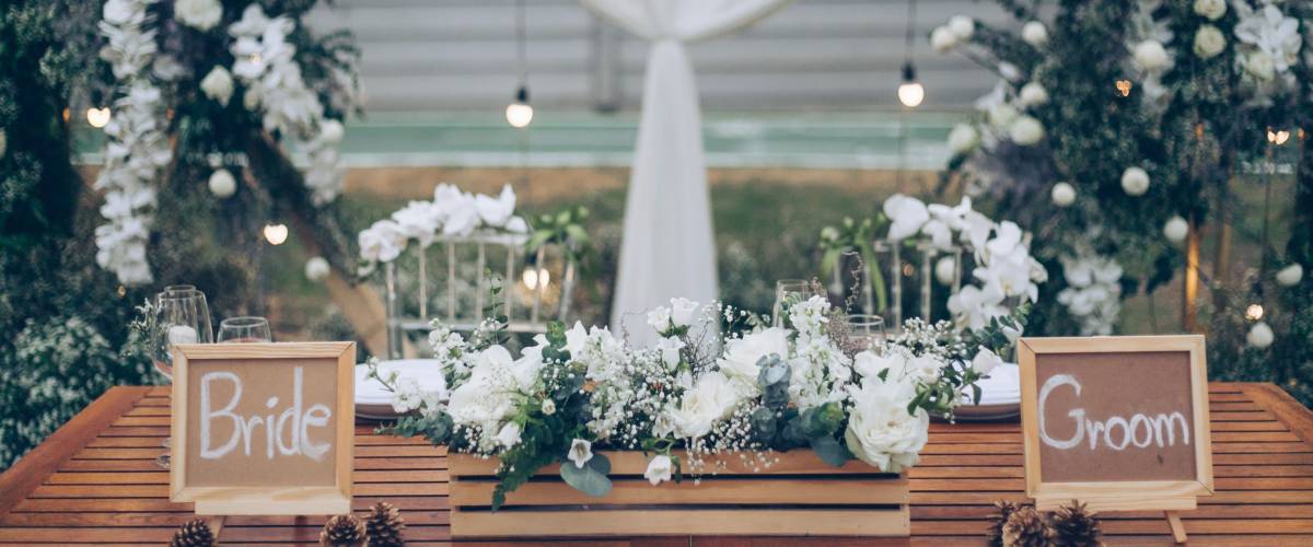bride and groom sign wood with bouquet white flowers on table , rustic wedding decoration blur background , wedding theme white and green