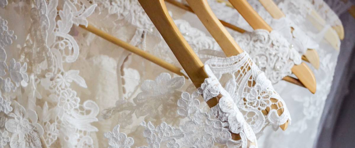 Wedding dresses hanging on a hanger. Fashion look. Interior of bridal salon.