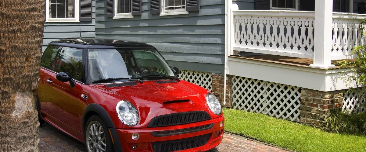 Red car in the driveway of a home