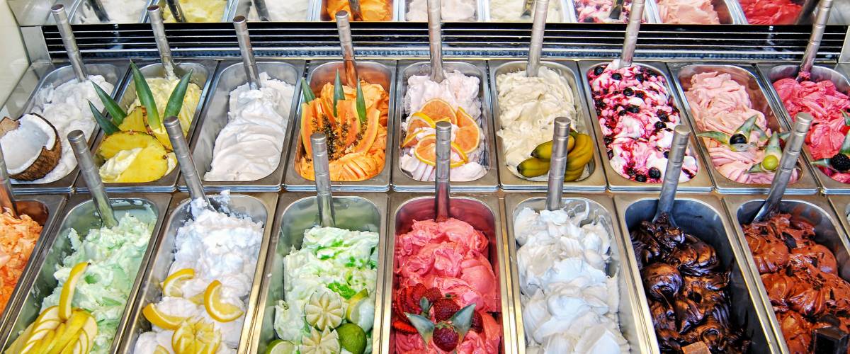 Display of assorted ice creams in metal tubs in a shop or ice cream parlour