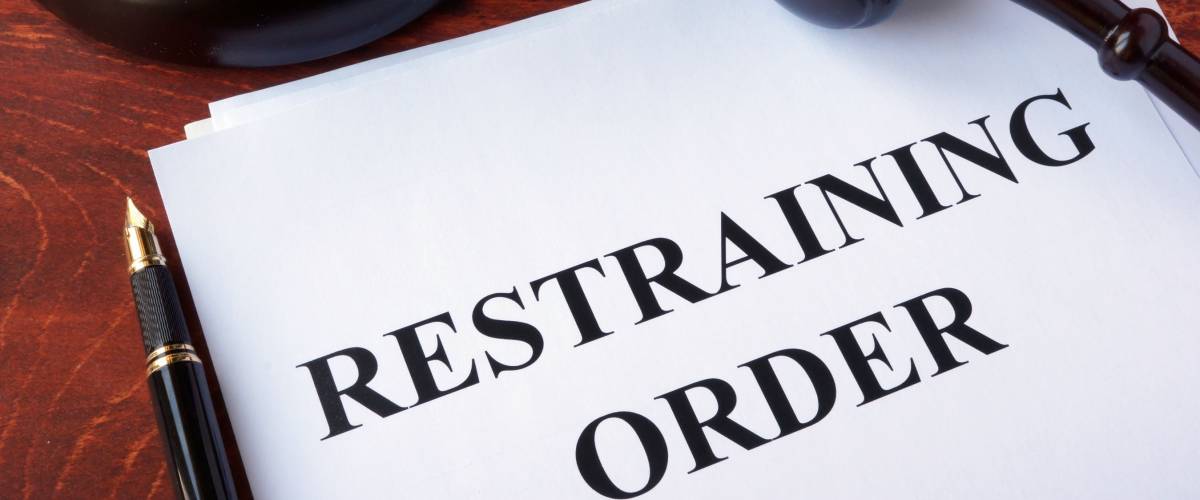 Restraining order and gavel on a table.