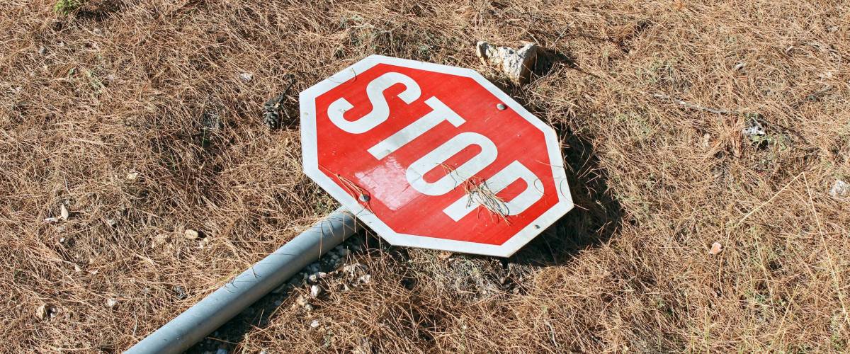 Broken stop traffic sign on the ground diagonal