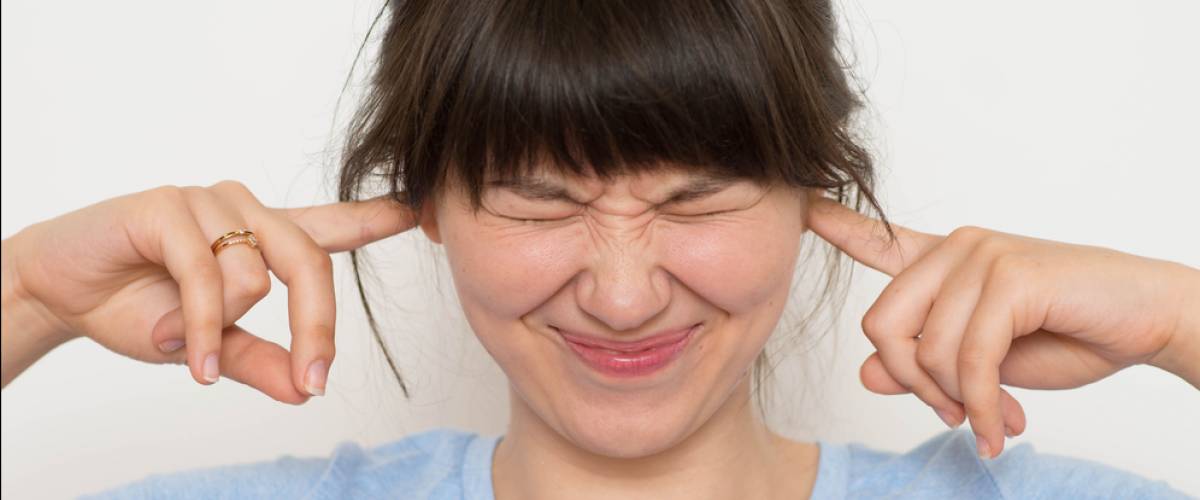 woman plug ears with fingers