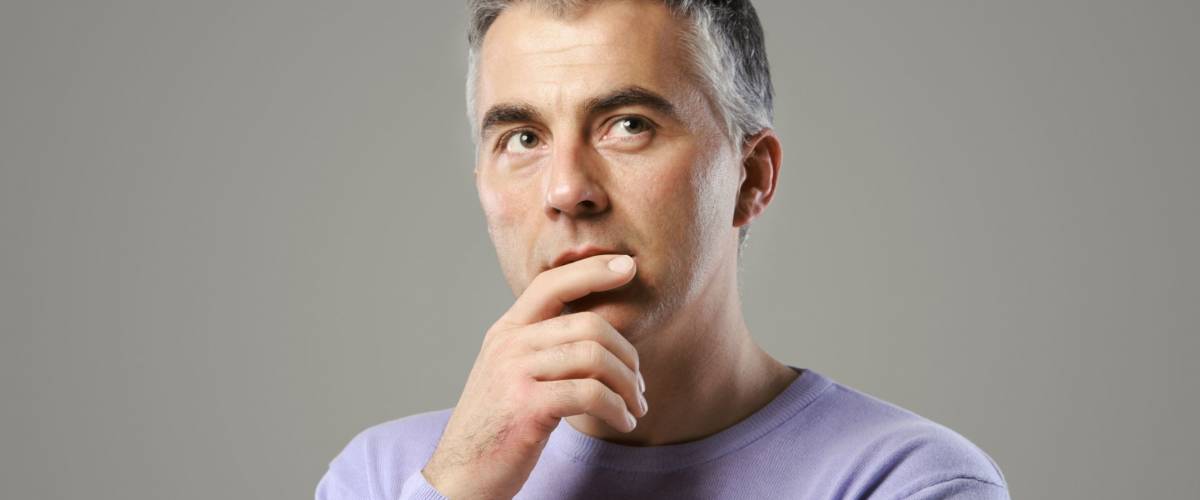 Portrait of casual man thinking and looking up