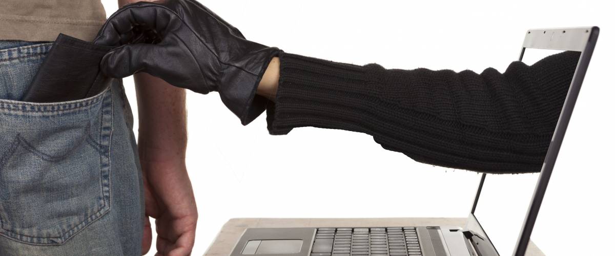 Internet theft - a gloved hand reaching through a laptop screen to steal a wallet from a man.
