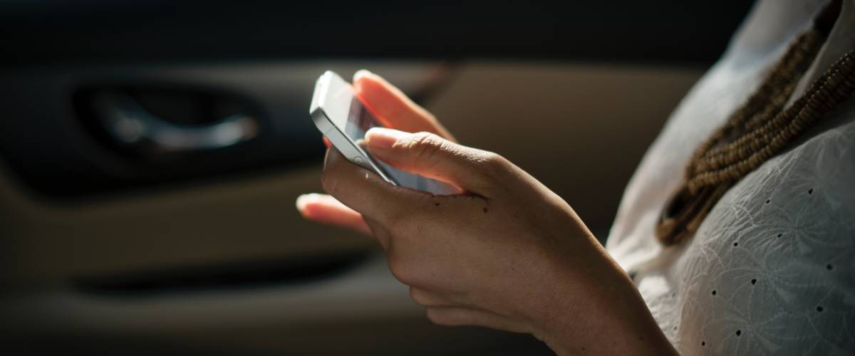 iPhone held by a woman in a car