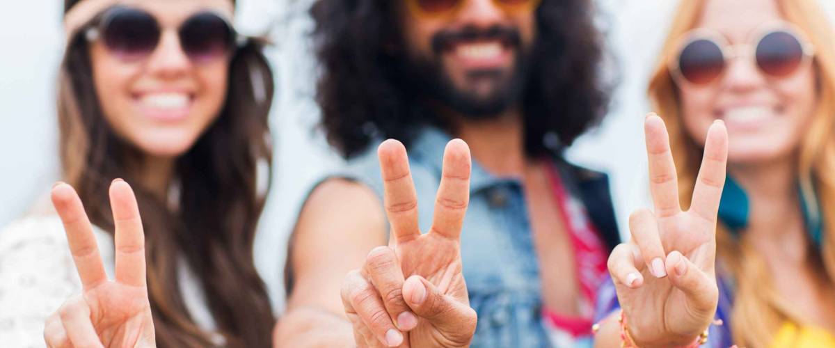 youth culture, gesture and people concept - smiling young hippie friends in sunglasses showing peace hand sign outdoors