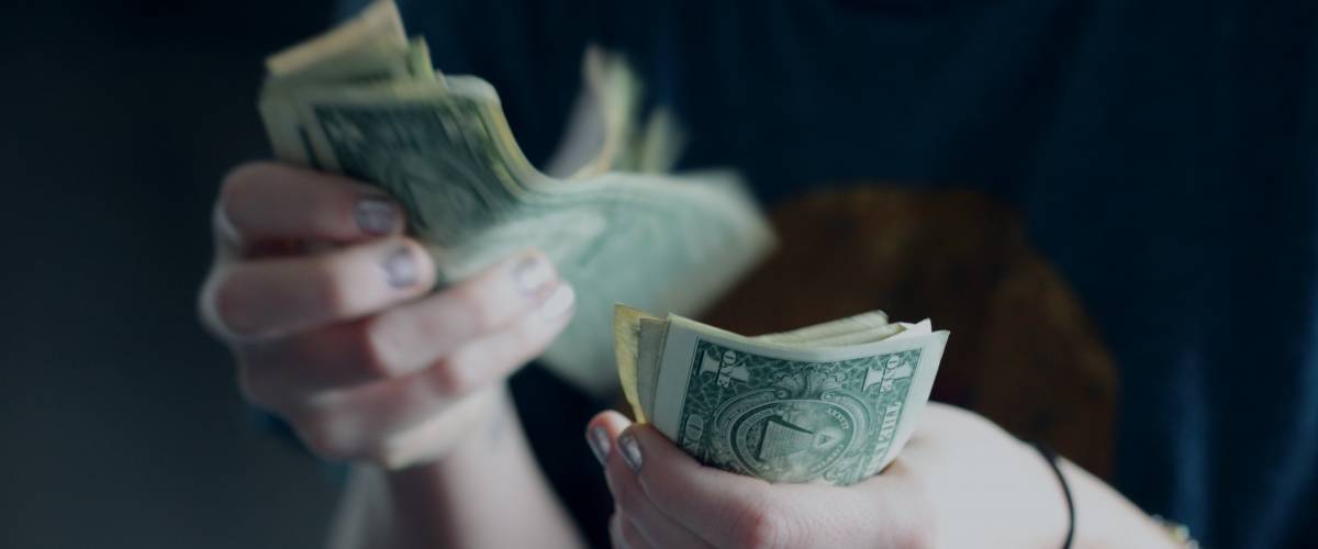 A person counting dollar bills