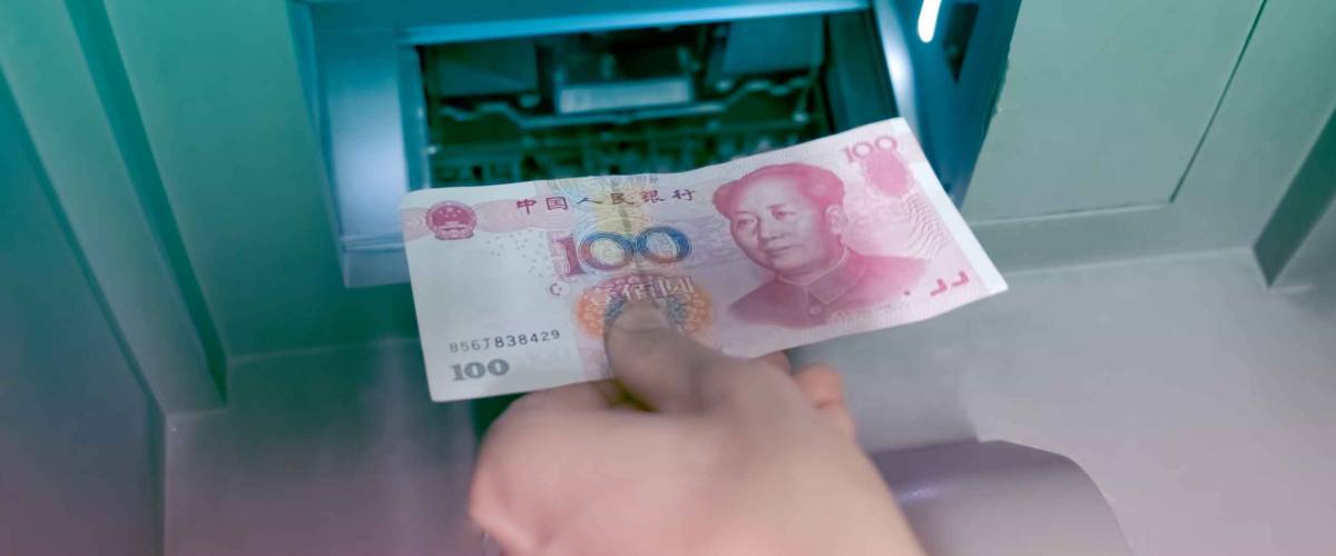 De la mano con el RMB chino colocado en el cajero automático, manténgalo en una cuenta bancaria de ahorro.