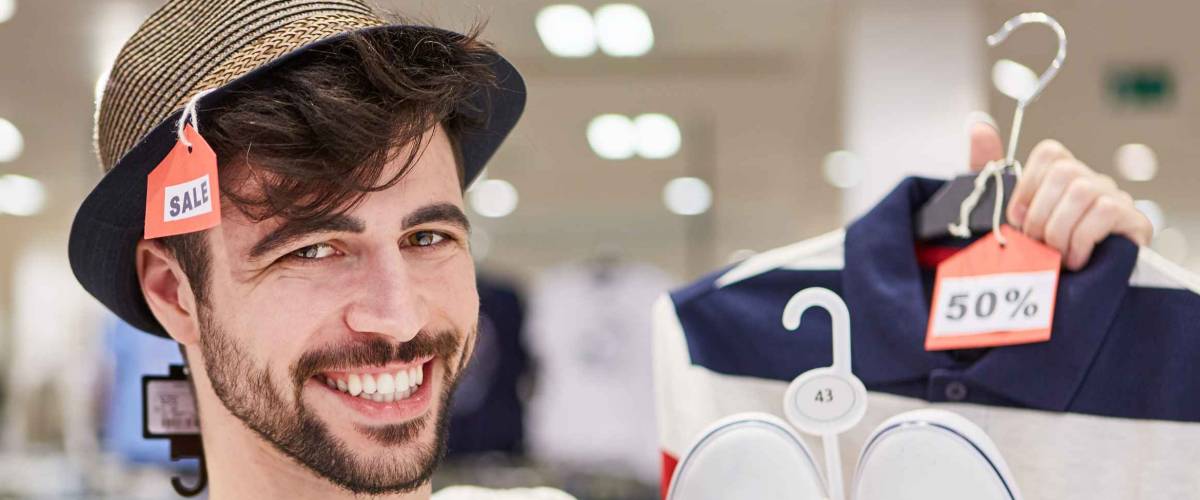 Happy young man shopping by fashion with 50% off discount