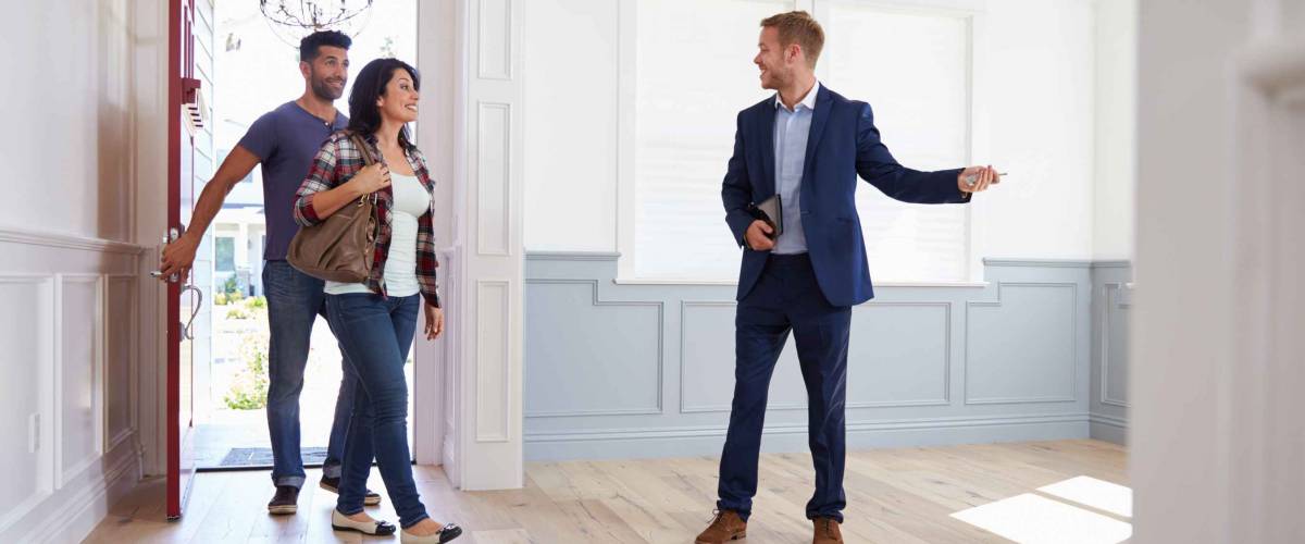 Realtor Showing Hispanic Couple Around New Home