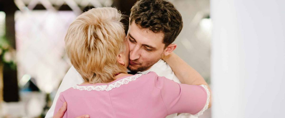 Older woman hugging her adult son