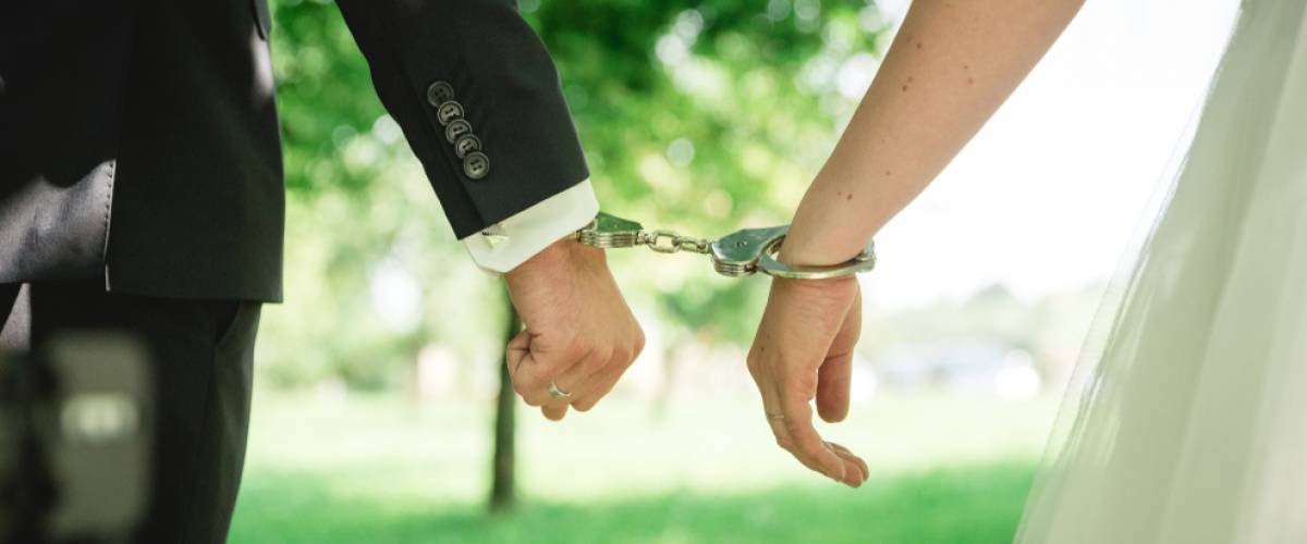 Bride and groom handcuffed together