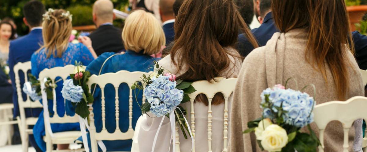 Guesting sitting in chairs during wedding ceremony