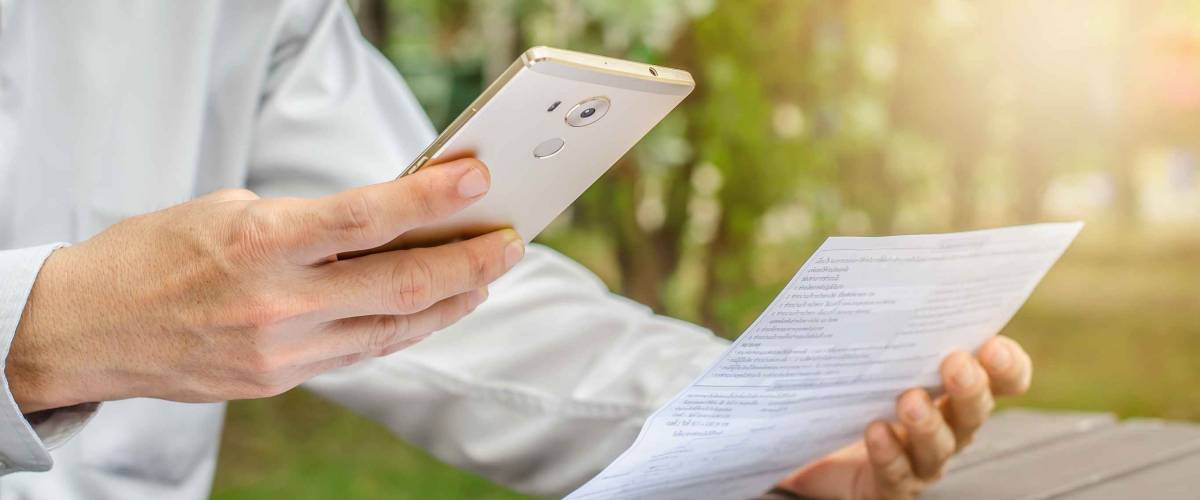 Businessman with bills and smart phone at the table. Calculation of costs