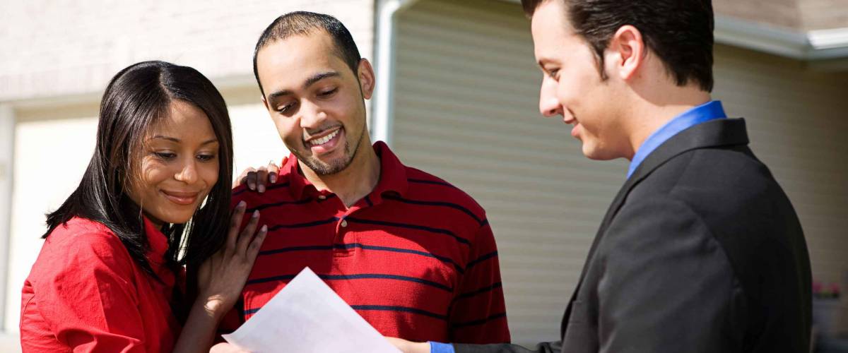 Real Estate: Agent Shows Information To Couple
