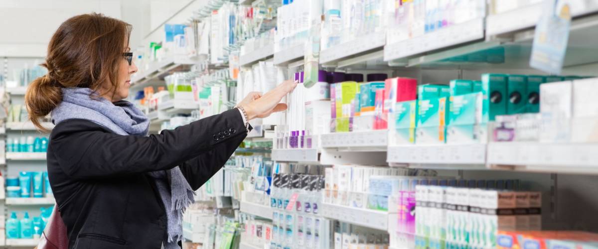 Mid adult female customer choosing product at pharmacy