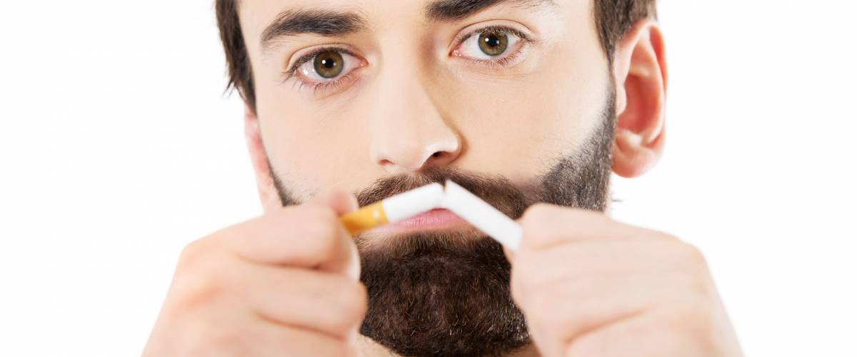 Businessman breaking a cigarette. Stop smoking concept.