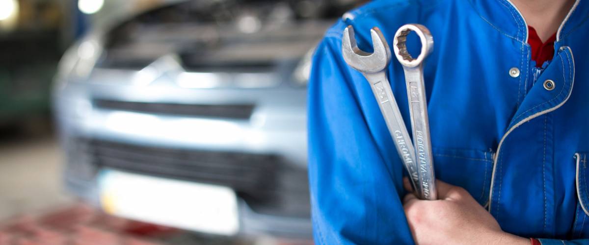 Hand of car mechanic with wrench. Auto repair garage.