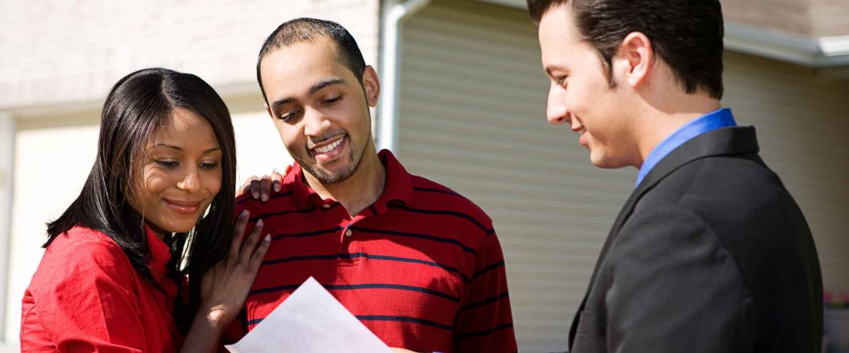 Real Estate: Agent Shows Information To Couple
