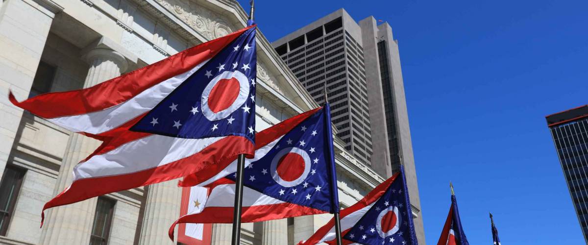 State of Ohio flags waving in front of the Statehouse in Columbus, OH