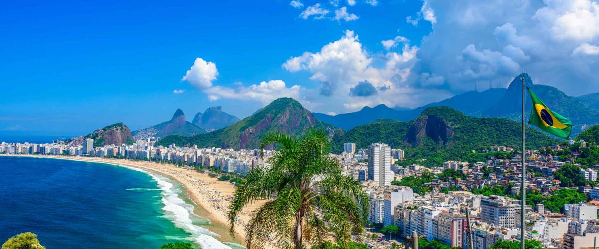 Copacabana beach in Rio de Janeiro, Brazil. Copacabana beach is the most famous beach of Rio de Janeiro, Brazil. Skyline of Rio de Janeiro with flag of Brazil