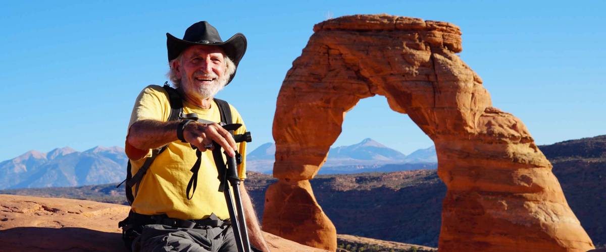 A senior hiker enjoying the views from the Delicate Arch area of Arches National Park.
