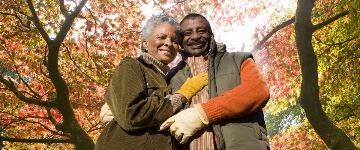 Senior African couple doing yard work in autumn