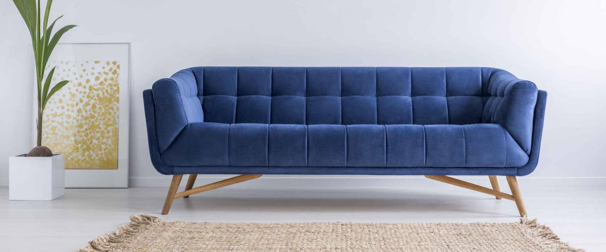Blue sofa and wicker carpet in white simple living room
