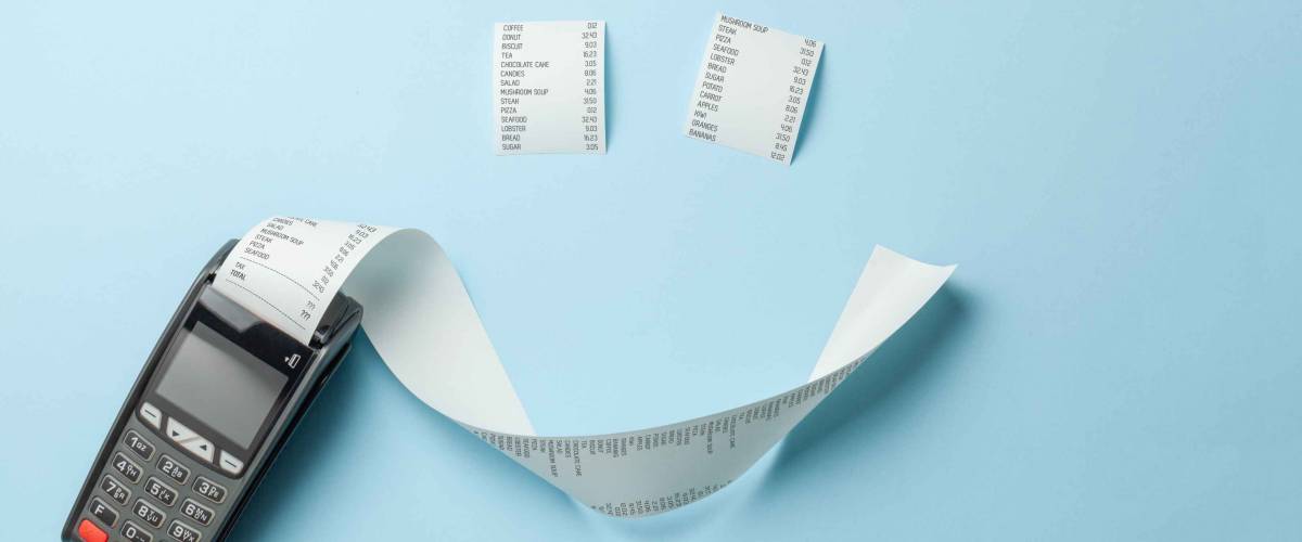 Terminal cash register machine POS for payments and long roll paper cash tape in the shape of smile on blue background