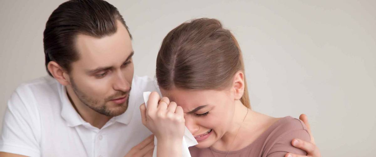 Upset crying woman wiping tears with handkerchief, loving boyfriend trying to comfort girlfriend embracing her, husband consoling depressed wife, support in difficult situation, compassion