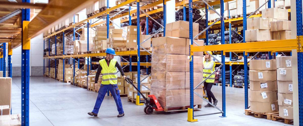 Warehouse workers pulling a pallet truck.
