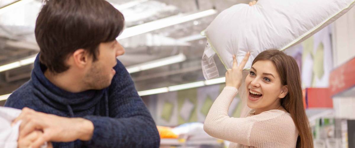 Woman hitting a man with a pillow