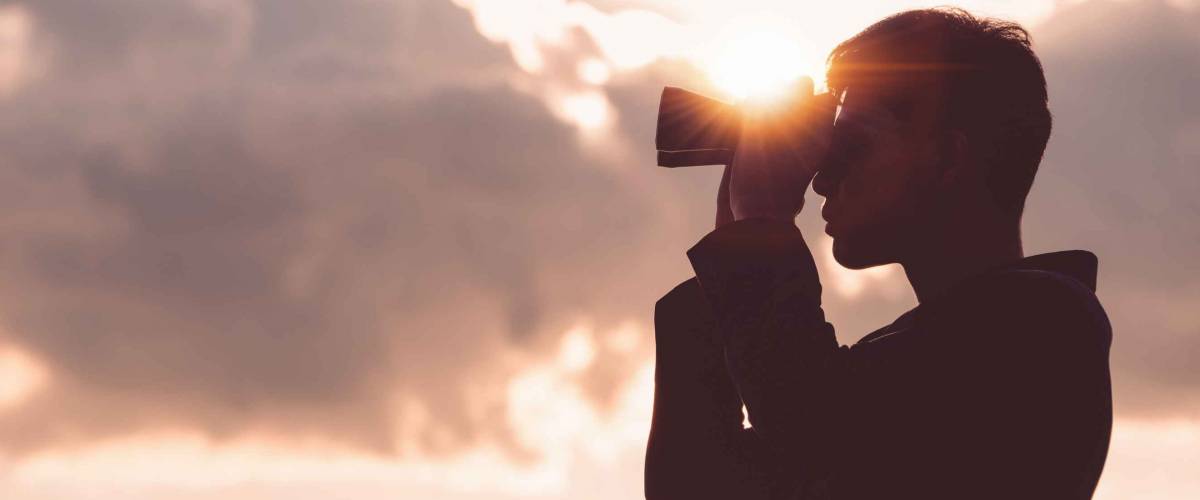 Asian man Hand Holding Binoculars / looking / watching using Binoculars with copyspace,Concept of The pursuit of profitable business in the future.