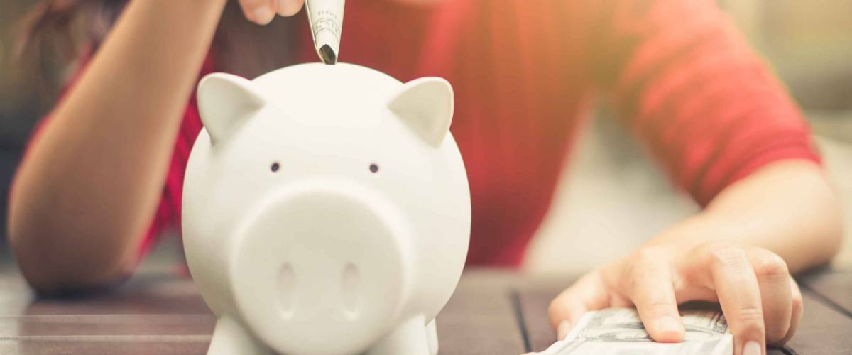 woman hand putting money bank note dollar into piggy for saving money wealth and financial concept.
